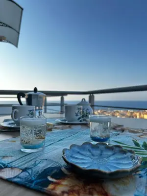 a table with a plate of food and two glasses at Sole Blue Apartment in Balestrate