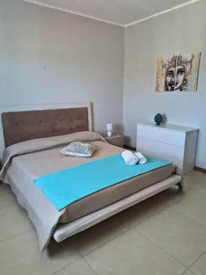 a bedroom with a bed and a painting on the wall at Sole Blue Apartment in Balestrate