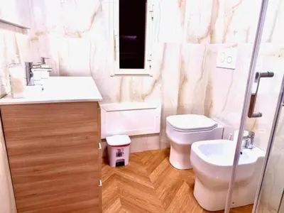 a white bathroom with a toilet and a sink at Casetta Lulù Palermo centro in Palermo