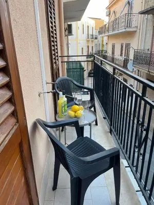 a table and chair on a balcony with fruit on it at Casa Sole e Limone in Castellammare del Golfo