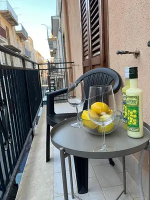 a table with two wine glasses and a bowl of lemons at Casa Sole e Limone in Castellammare del Golfo