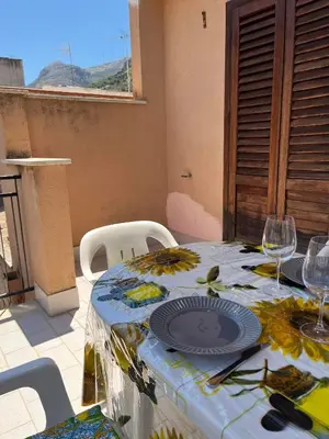 a table with plates and glasses on top of it at Casa Sole e Limone in Castellammare del Golfo