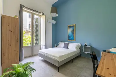 a bedroom with a bed and a blue wall at Panurban Apartments by Wonderful Italy in Palermo