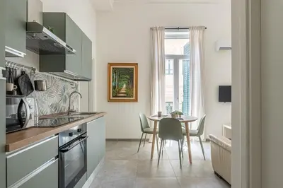 a kitchen with a table and a dining room at Panurban Apartments by Wonderful Italy in Palermo