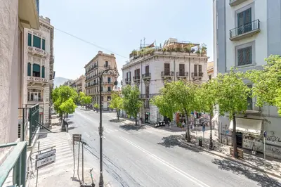 an empty city street with trees and buildings at Panurban Apartments by Wonderful Italy in Palermo