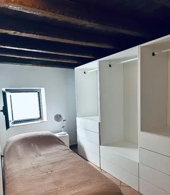 a bedroom with white cabinets and a bed at Cala Costa in Palermo