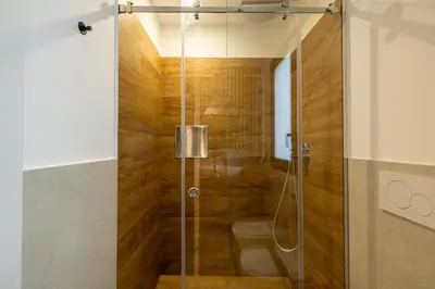 a shower with a glass door in a bathroom at Suite le palme in Aspra