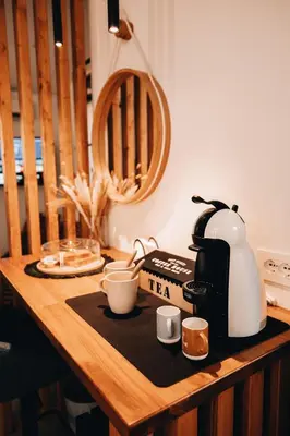 a coffee maker and cups on a wooden table at Suite le palme in Aspra