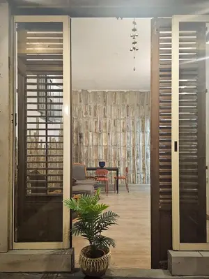 a door leading into a living room with a plant at A al Quadrato in Palermo