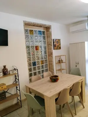 a dining room with a wooden table and chairs at Joy House in Palermo