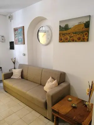 a living room with a couch and a clock on the wall at Joy House in Palermo