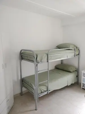 a metal bunk bed in a white room at Joy House in Palermo