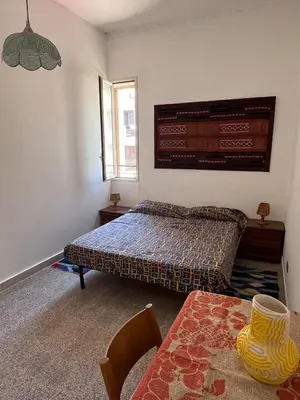 a bedroom with a bed and a table in it at Corso Tugher in Palermo