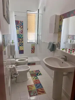a white bathroom with a toilet and a sink at Corso Tugher in Palermo