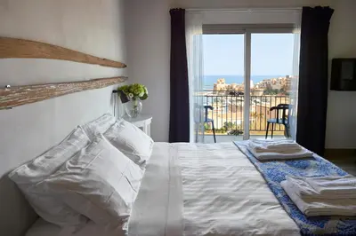 a bedroom with a bed with a view of the ocean at Santina Suites in Castellammare del Golfo