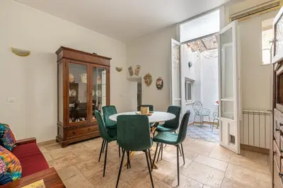 a dining room with a table and green chairs at Giudici Three Bedrooms Apartment by Wonderful Italy in Palermo