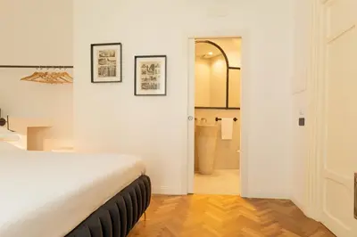 a white bedroom with a bed and a bathroom at Limes in Palermo
