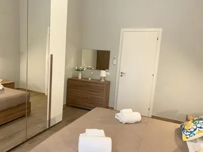 a bedroom with a mirror and a bed with towels at Lucrezio Houses in Palermo