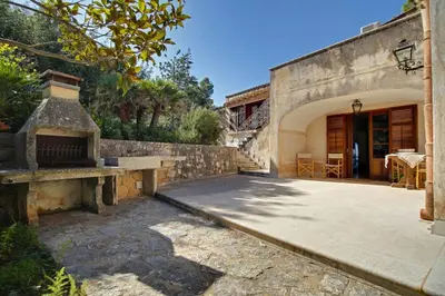 a stone house with a patio and a table at Poggio di mare in Castelluzzo