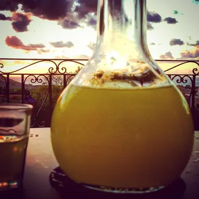 a bottle of orange juice sitting on a table with a glass at Poggio di mare in Castelluzzo