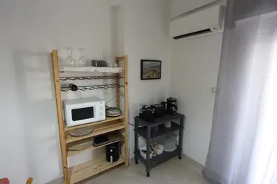 a small kitchen with a microwave and a shelf with a microwave at Appartamento La Rosa dei Venti in Porticello