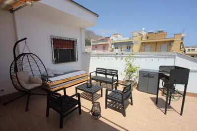 a patio with chairs and a bench and a swing at Appartamento La Rosa dei Venti in Porticello