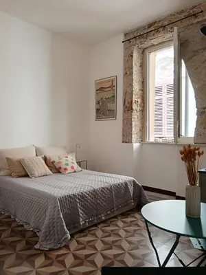 a bedroom with a bed and a table and a window at Campofranco Studio in Palermo