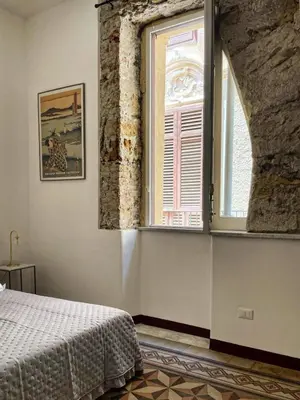 a bedroom with a bed and a large window at Campofranco Studio in Palermo
