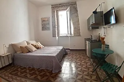 a bedroom with a bed and a television and a table at Campofranco Studio in Palermo