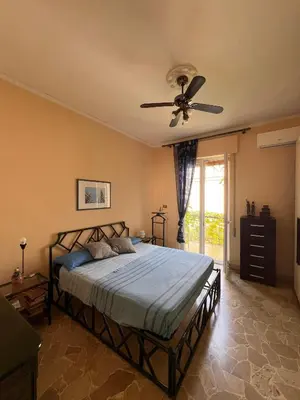 a bedroom with a bed with a ceiling fan at La terrazza sul mare in Palermo