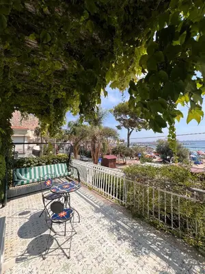 a table and chair on a patio with a view of the ocean at La terrazza sul mare in Palermo