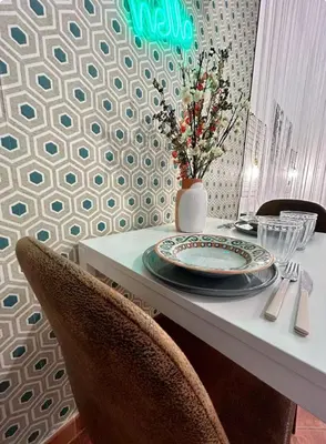 a table with a plate and a vase with flowers on it at Casamori 2- nel cuore di Palermo, mercato Ballarò in Palermo