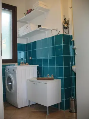 a bathroom with a washing machine and a washer at Agave Scopello in Scopello