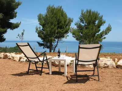 two chairs and a table and a table and chairs at Agave Scopello in Scopello