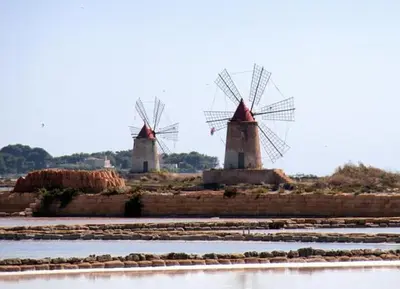 two windmills on an island in the water at Agave Scopello in Scopello
