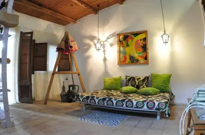 a room with a couch and a painting and a ladder at Casa Ninfee, immersa nel verde con piscina in comune in Terrasini
