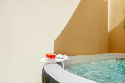 a tray with two drinks on top of a bath tub at Colonna Secret, Private Jacuzzi in Historic Center in Palermo