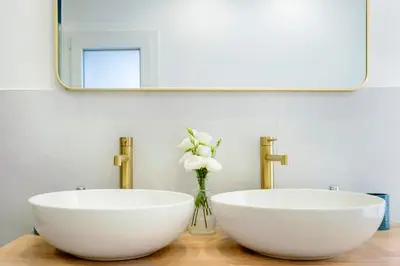 a bathroom with two white sinks and a mirror at Colonna Secret, Private Jacuzzi in Historic Center in Palermo