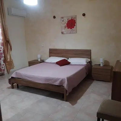 a bedroom with a large bed with two night stands at Maria Isabella appartament in Isola delle Femmine