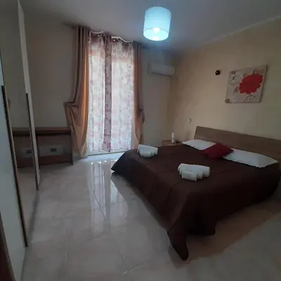 a bedroom with a large bed and a large window at Maria Isabella appartament in Isola delle Femmine