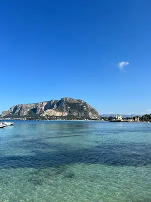 a view of the ocean with an island in the background at Ashur Mondello, sapore di sale in Palermo