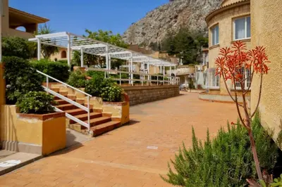 a building with stairs and plants and a mountain at Ashur Mondello, sapore di sale in Palermo
