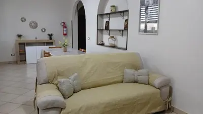 a living room with a couch and a kitchen at West Sicily Beach in Balestrate