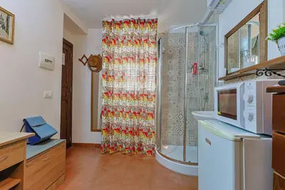 a shower curtain in a kitchen with a microwave at La casettina di Dante in Palermo