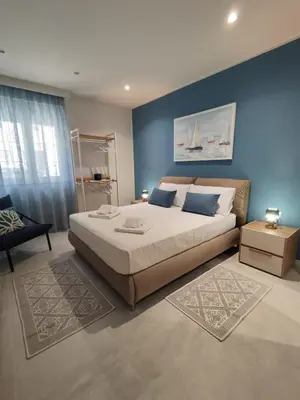 a bedroom with a large bed and a blue wall at Molly house in Palermo