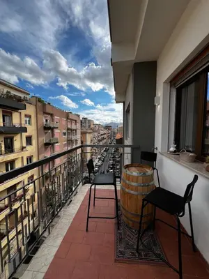 a balcony with chairs and a barrel on a balcony at Guardian Dream Suite House nel cuore di Palermo in Palermo