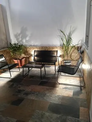 a patio with two black benches and potted plants at Wellness House in Bagheria