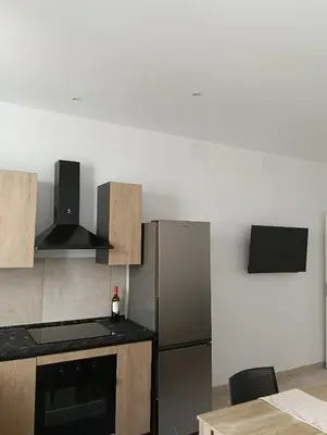 a kitchen with a stainless steel refrigerator and a table at Wellness House in Bagheria