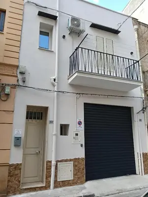 a building with a garage door and a balcony at Wellness House in Bagheria
