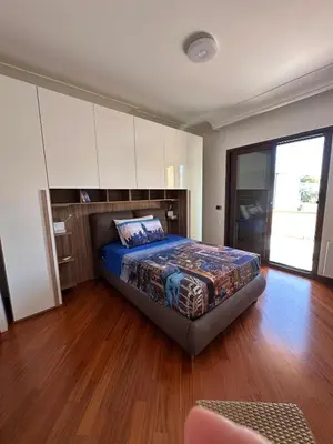 a bedroom with a bed in a room with wooden floors at Villa Oasi Bonita a Mondello in Palermo